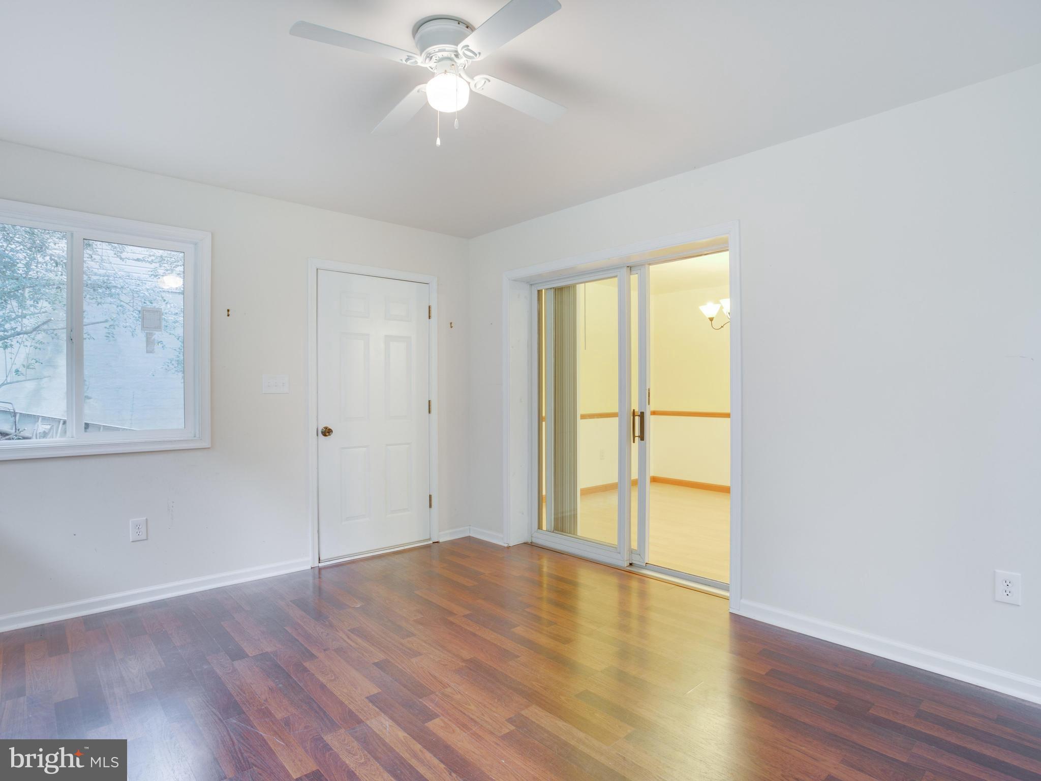 11893 Little Cove Point Road Lusby, MD 20657 - Photo 16 of 18 an empty room with wooden floor and windows