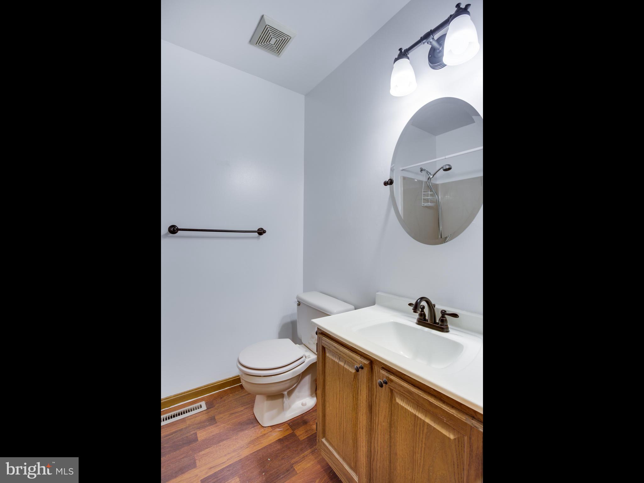 11893 Little Cove Point Road Lusby, MD 20657 - Photo 18 of 18 a bathroom with a granite countertop toilet sink and mirror