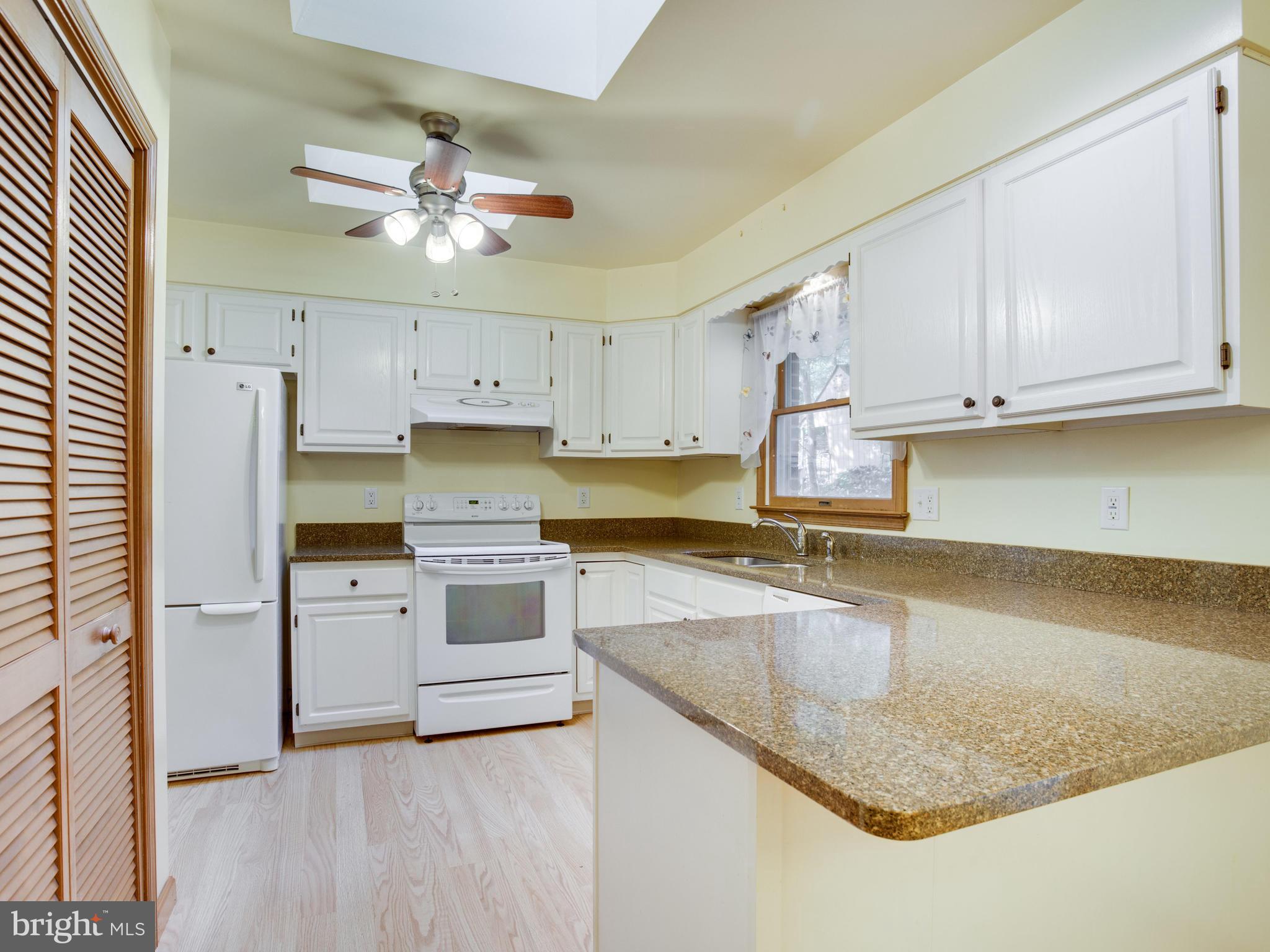 11893 Little Cove Point Road Lusby, MD 20657 - Photo 5 of 18 a kitchen with granite countertop a sink stainless steel appliances and cabinets
