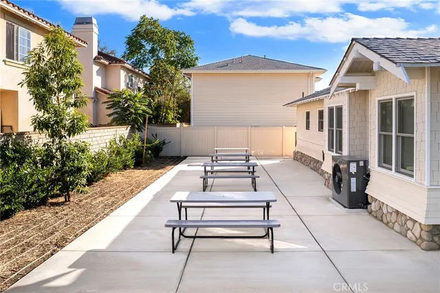 a view of a patio with couches table and chairs and potted plants