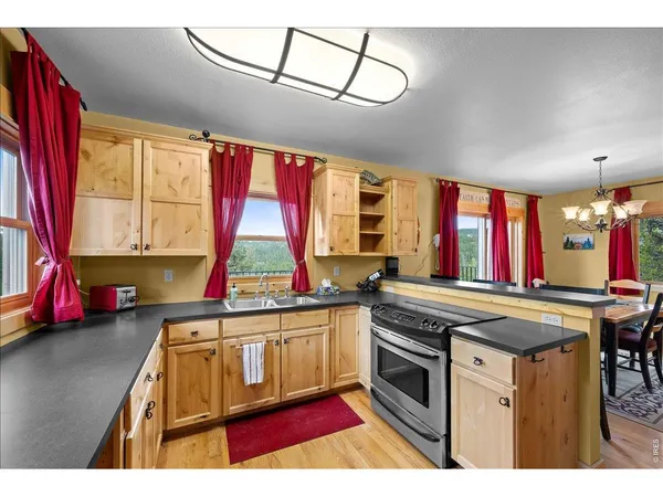 a kitchen with stainless steel appliances granite countertop a stove a sink and a microwave