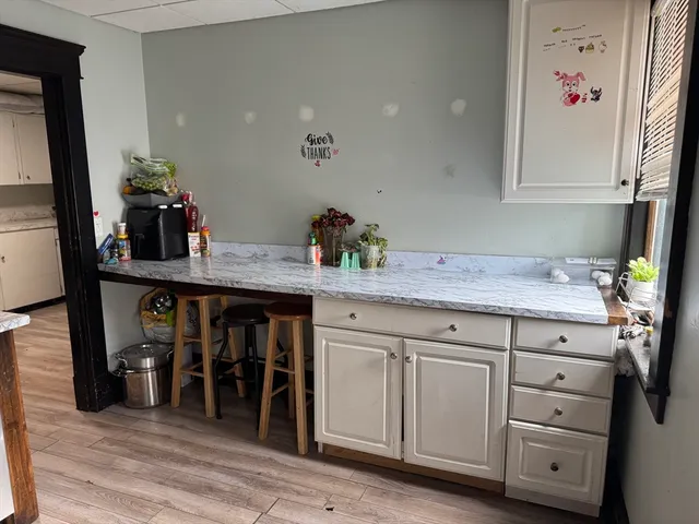 a kitchen with cabinets appliances and wooden floor