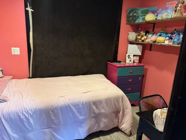 a bedroom with a bed dresser and a window