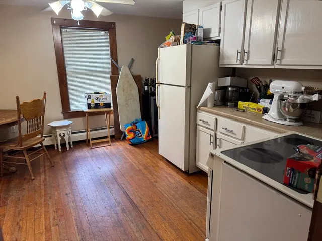 a kitchen with sink a refrigerator and wooden floor