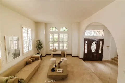 a living room with furniture and a dining table with wooden floor