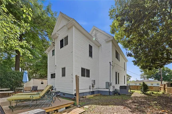a white house covered with tall trees