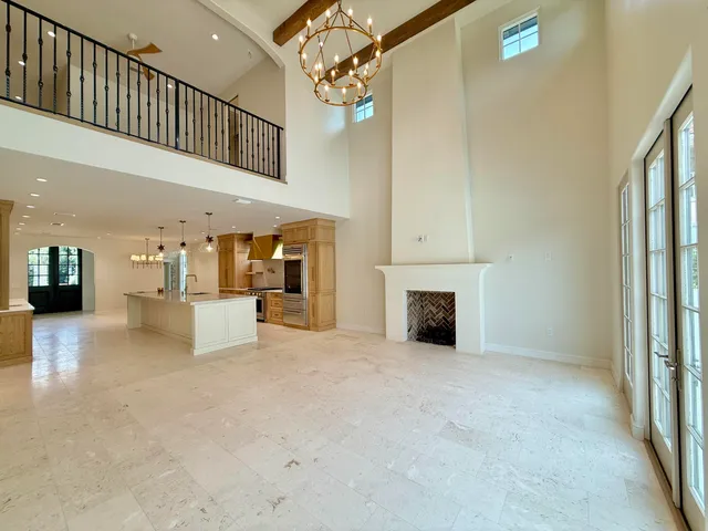 an empty room with wooden floor ceiling fan and windows