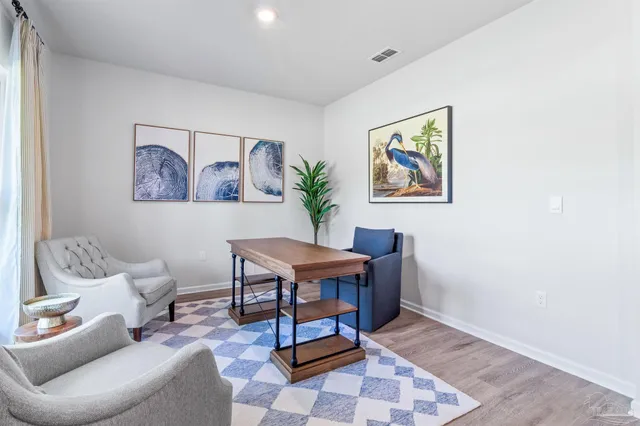 a living room with furniture and paintings on the wall