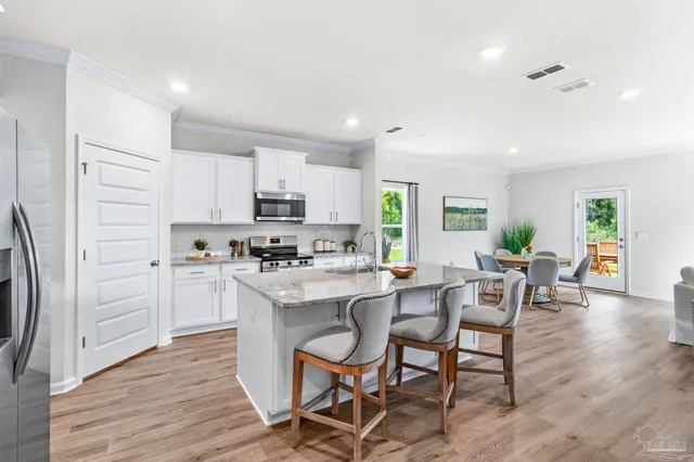 a kitchen with white cabinets and stainless steel appliances