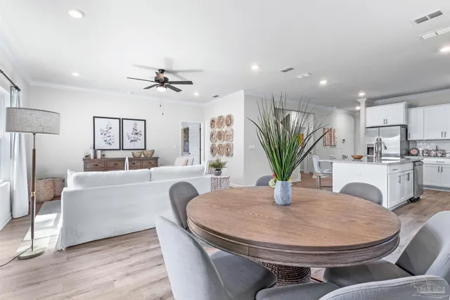 a living room with stainless steel appliances furniture a dining table with kitchen view