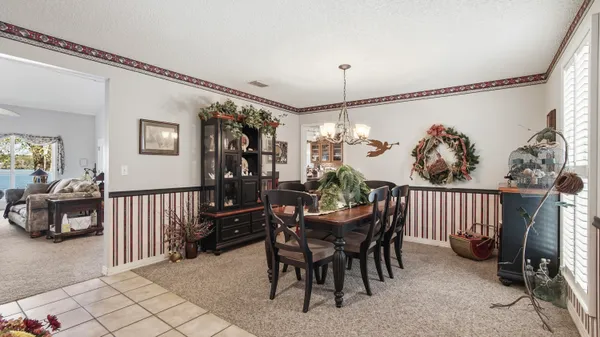 a living room with furniture a fireplace and a chandelier