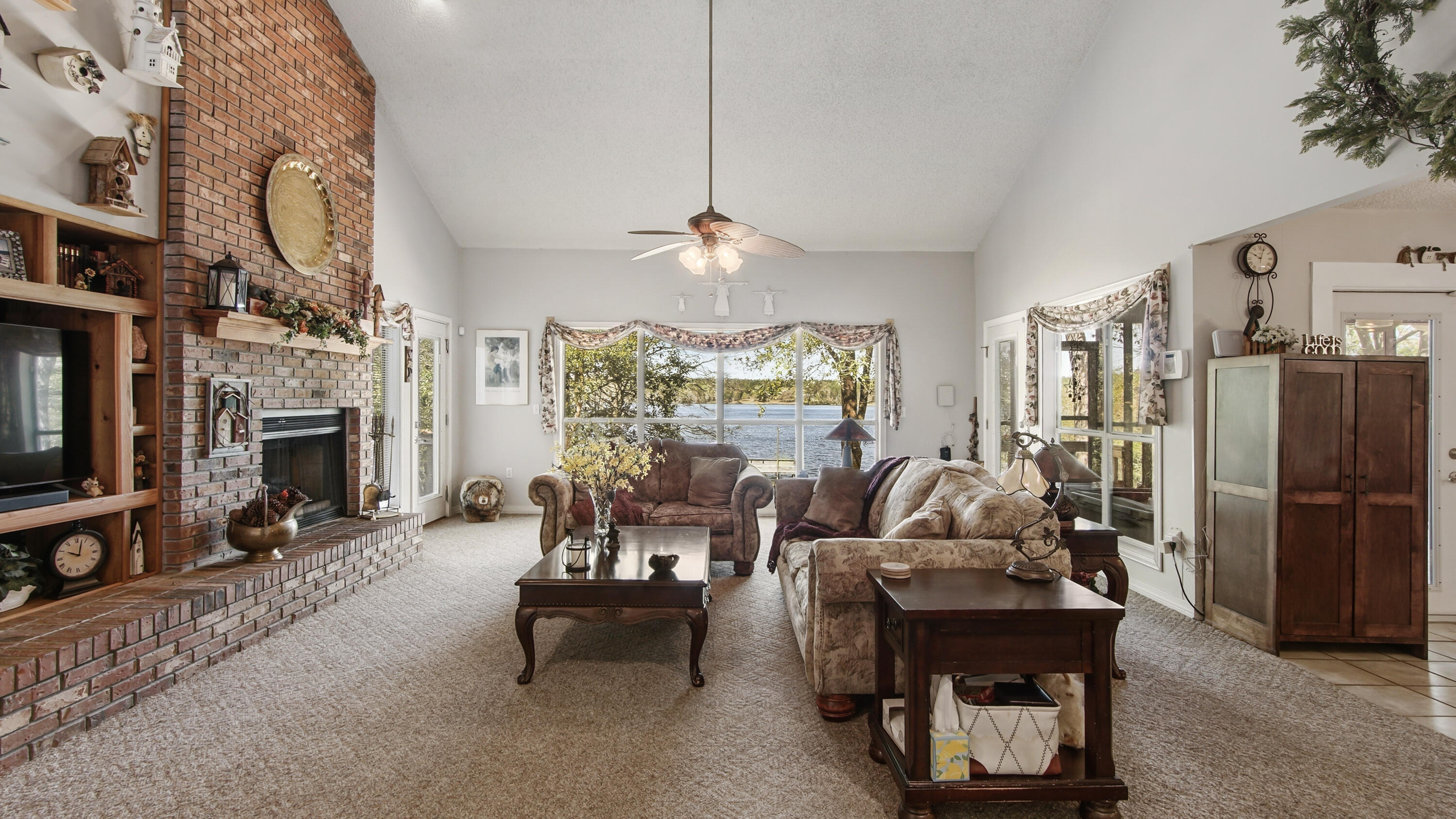 2272 Spring Lake Road DeFuniak Springs, FL 32433 - Photo 16 of 48 a living room with furniture a fireplace and a chandelier