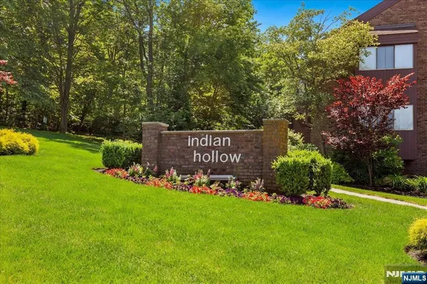 a view of a sign in front of a house with a big yard
