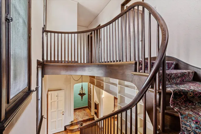a view of staircase with railing and white walls