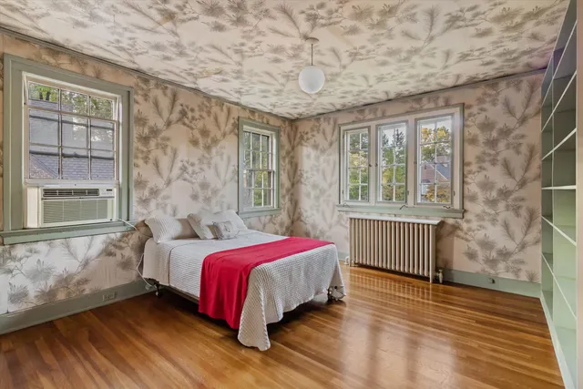 a bedroom with a bed and wooden floor