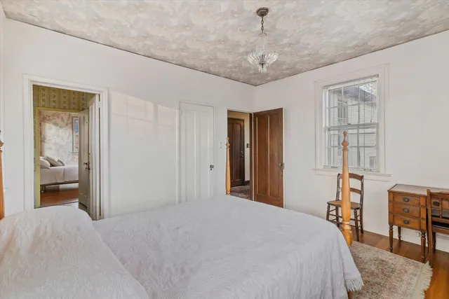 a bedroom with a bed and a chandelier