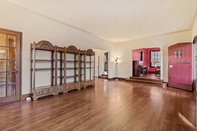 a view of a bedroom with wooden floor and window