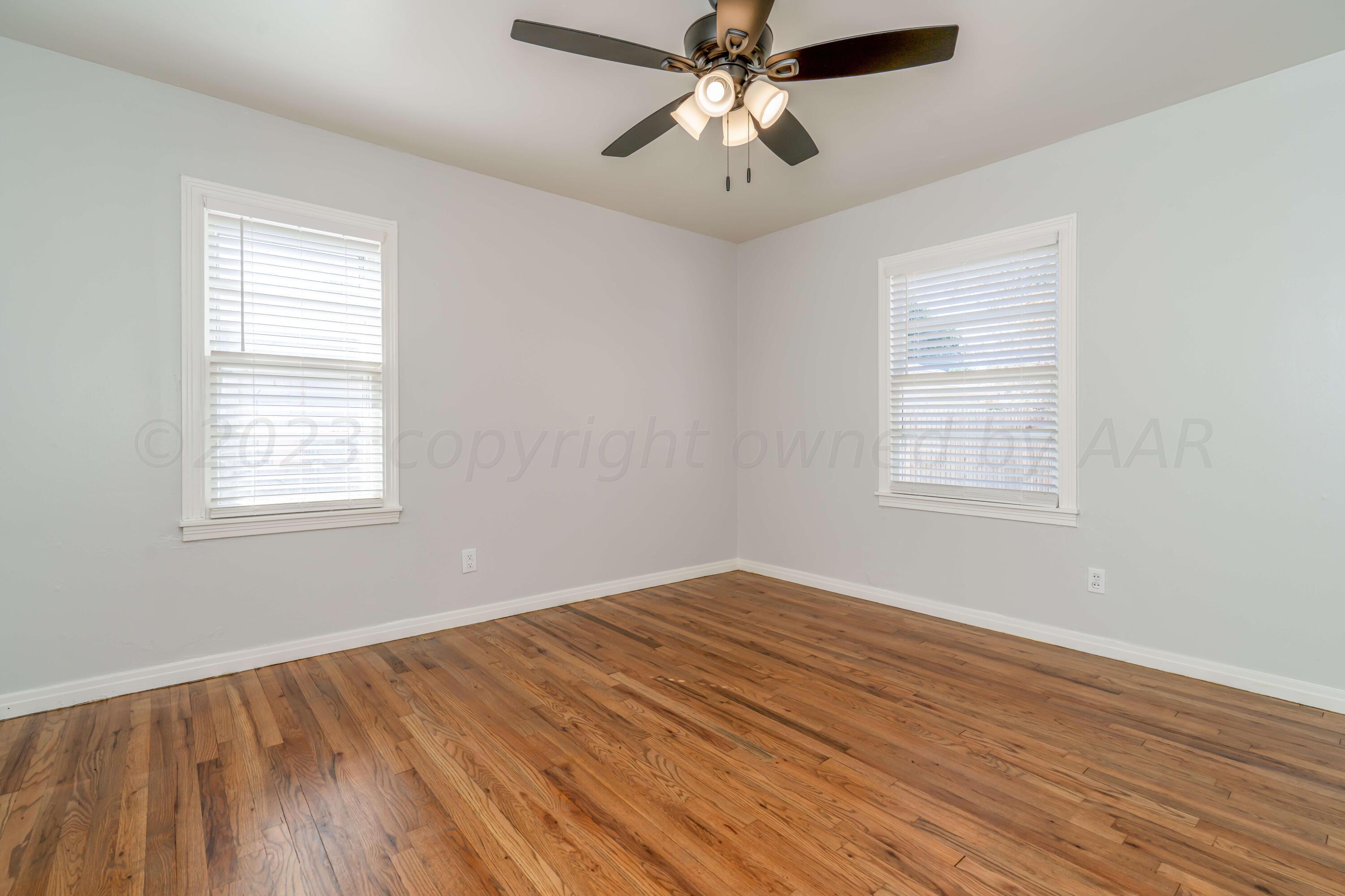 4306 Parker Street Amarillo, TX 79110 - Photo 13 of 29 a view of empty room with wooden floor and fan