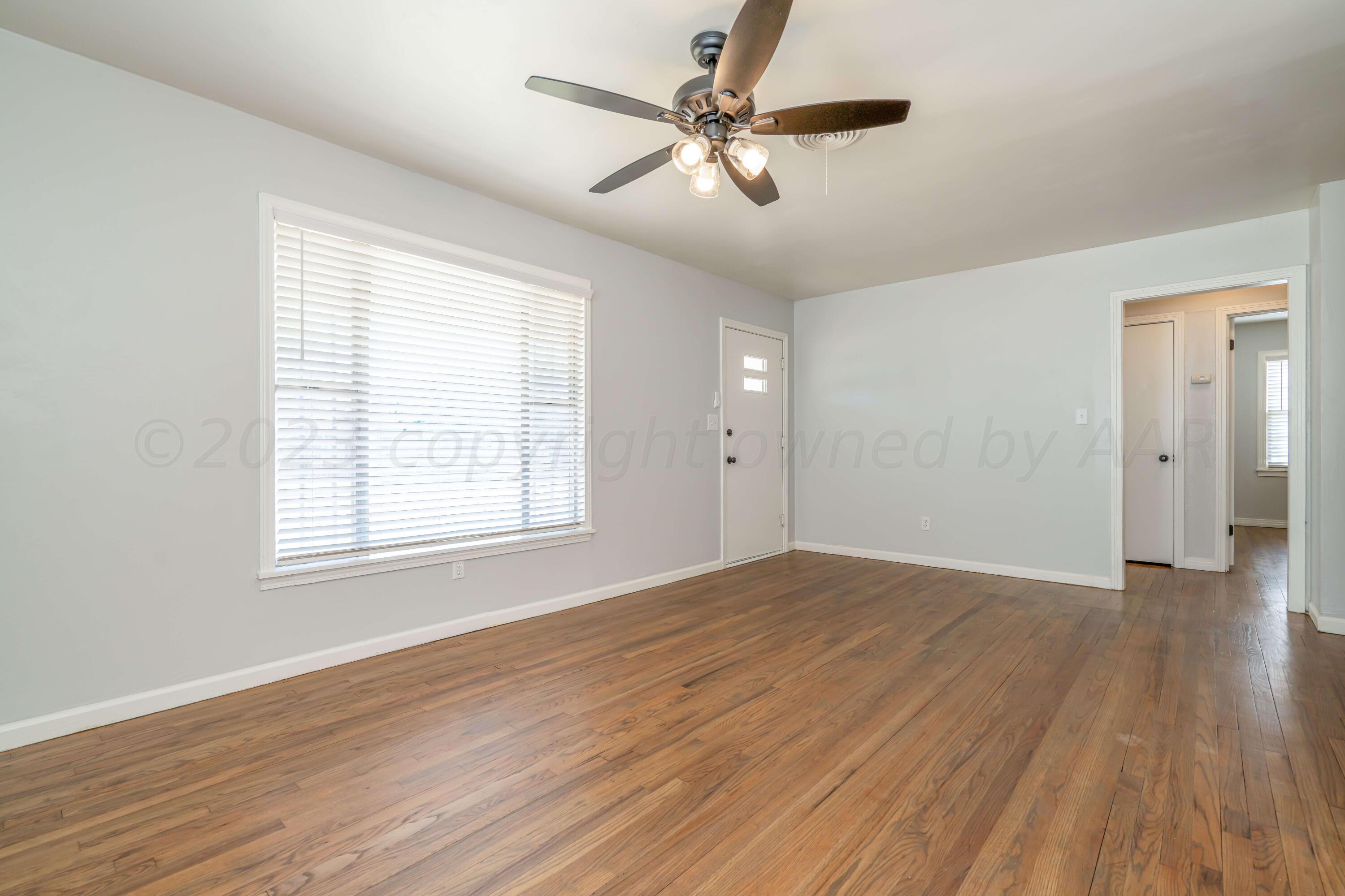 4306 Parker Street Amarillo, TX 79110 - Photo 20 of 29 an empty room with wooden floor ceiling fan and windows