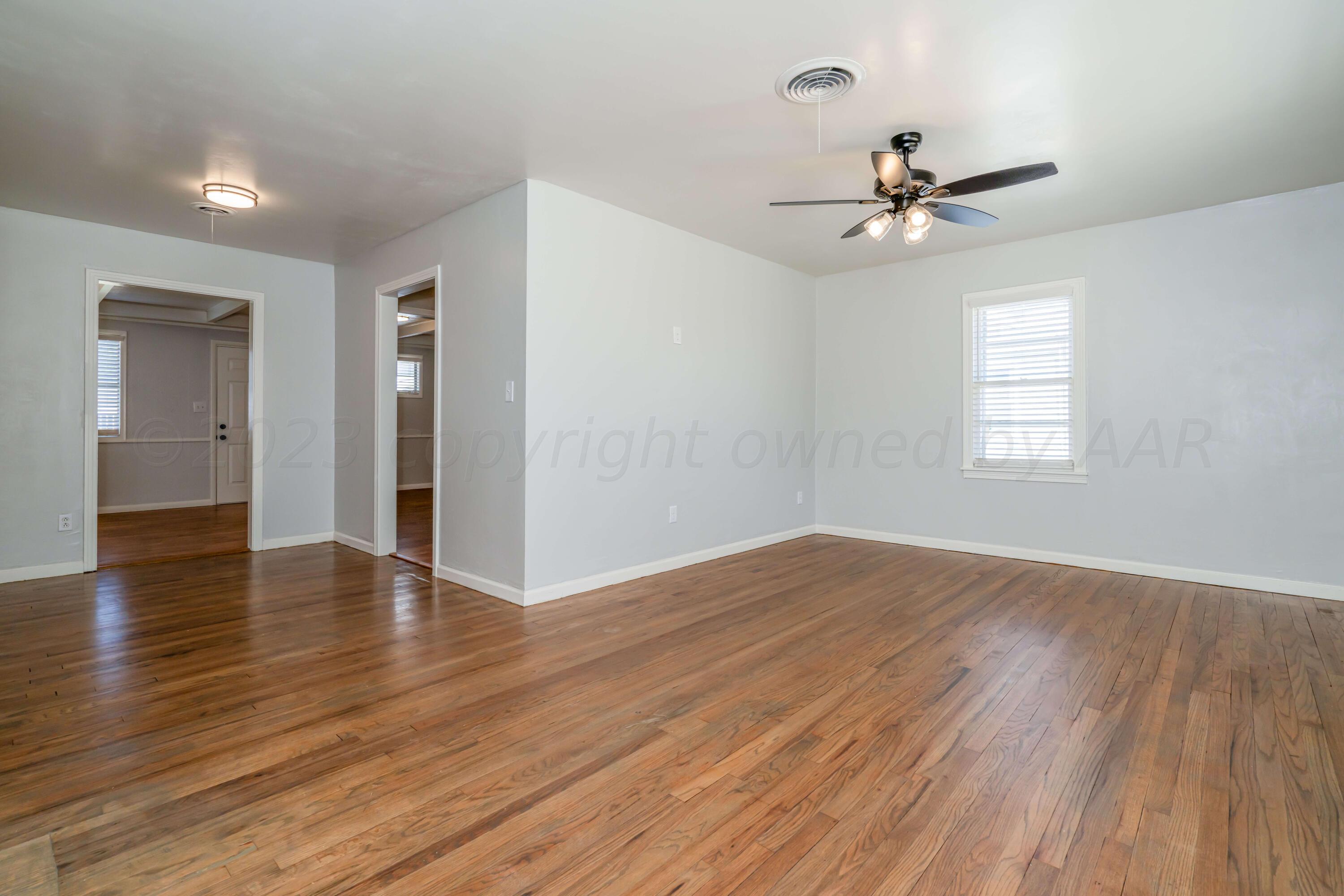 4306 Parker Street Amarillo, TX 79110 - Photo 6 of 29 a view of an empty room with wooden floor and a window