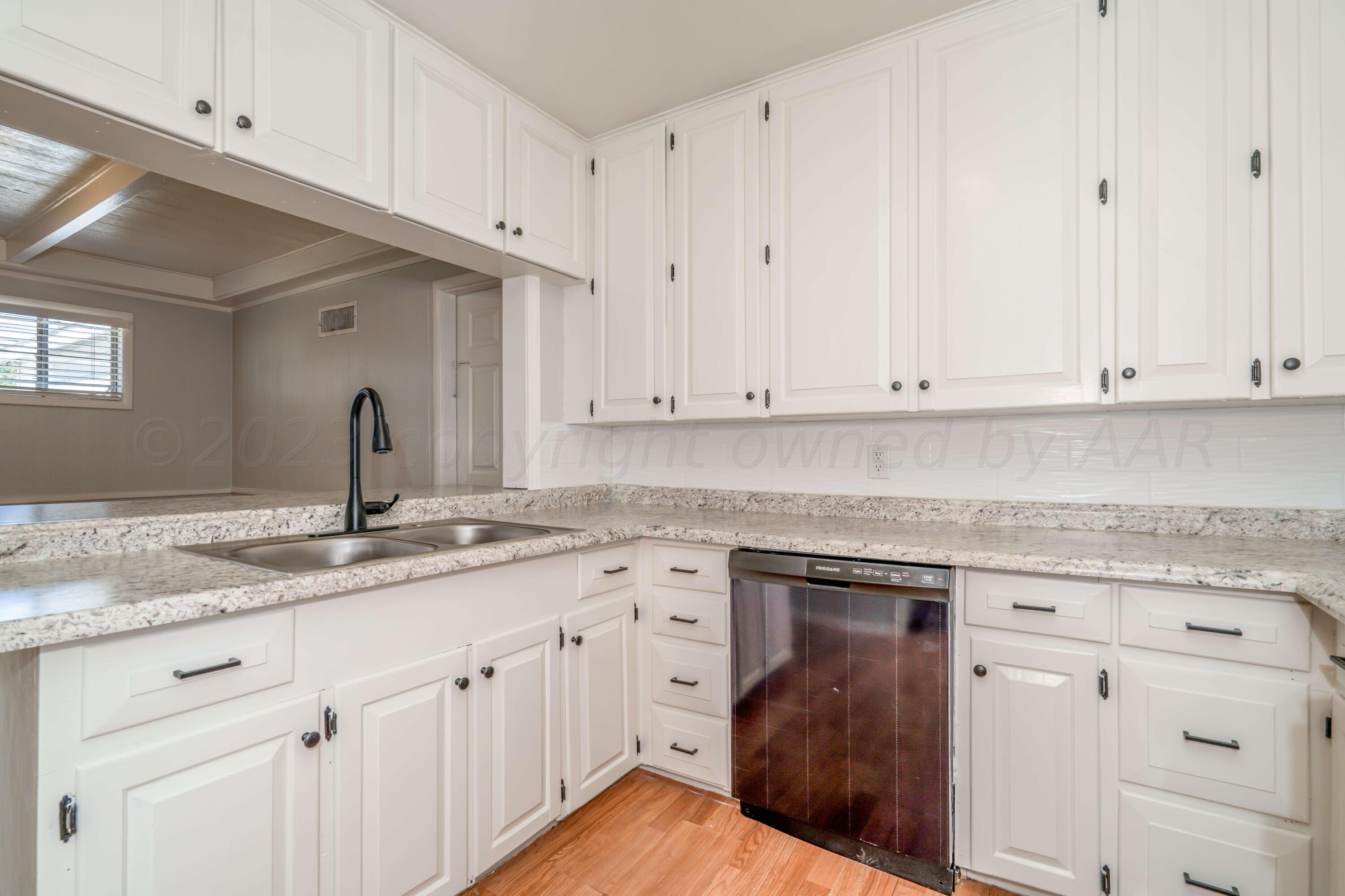 4306 Parker Street Amarillo, TX 79110 - Photo 9 of 29 a kitchen with granite countertop white cabinets and a sink
