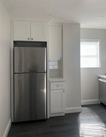 a view of a refrigerator in kitchen and wooden floor