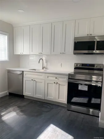 a kitchen with stainless steel appliances white cabinets and a sink