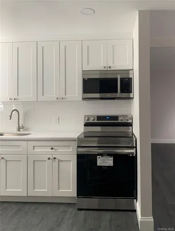 a kitchen with white cabinets and stainless steel appliances