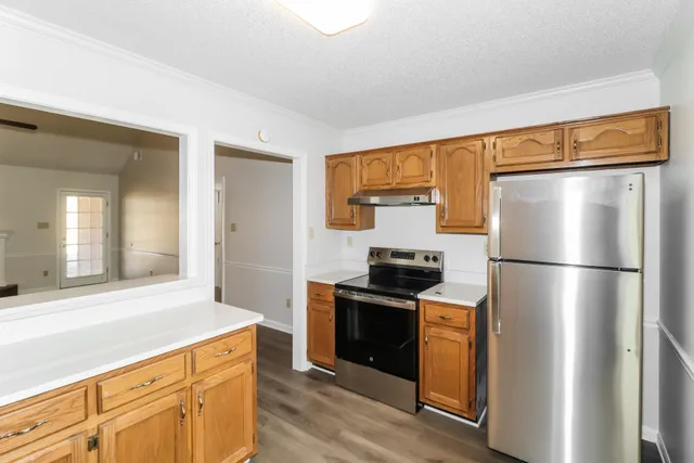 a kitchen with a refrigerator a stove a sink and a window
