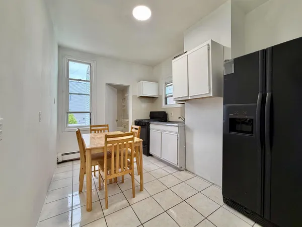 a kitchen with a refrigerator a table and chairs in it