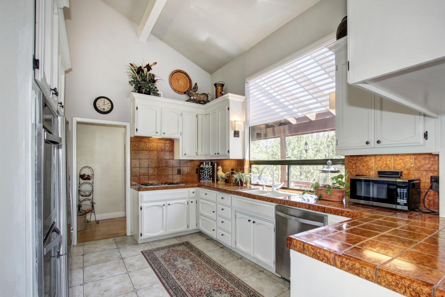 18119 Norlene Way Grass Valley, CA 95949 - Photo 24 of 93 a kitchen with stainless steel appliances granite countertop a stove a sink and a refrigerator