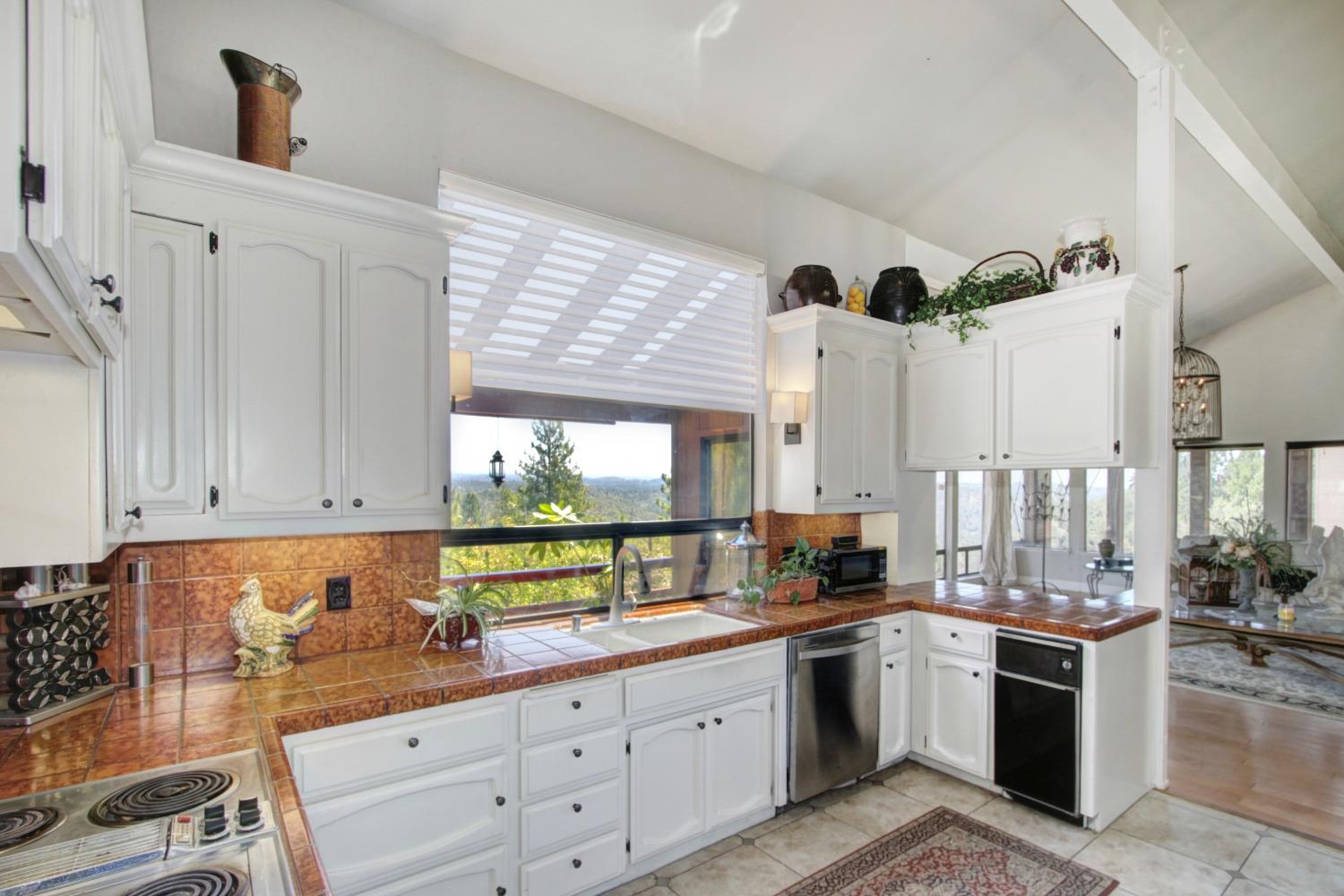 18119 Norlene Way Grass Valley, CA 95949 - Photo 25 of 93 a kitchen with granite countertop white cabinets and white appliances