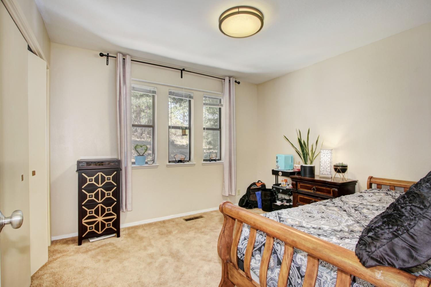 18119 Norlene Way Grass Valley, CA 95949 - Photo 69 of 93 a bedroom with a bed and a dresser