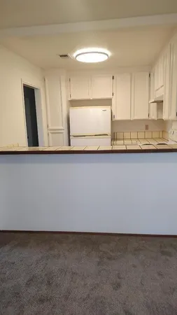 a kitchen with granite countertop a sink a stove and cabinets