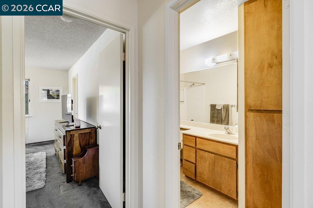 1123 Chadwick Circle Bay Point, CA 94565 - Photo 16 of 26 Bathroom with a textured ceiling, light carpet, and vanity