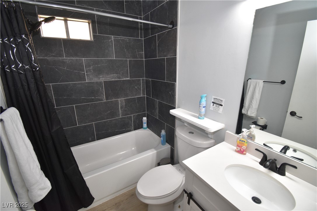 5045 Spencer Street, Unit B Las Vegas, NV 89119 - Photo 13 of 23 Full bath featuring shower / tub combo with curtain, vanity, and wood finished floors