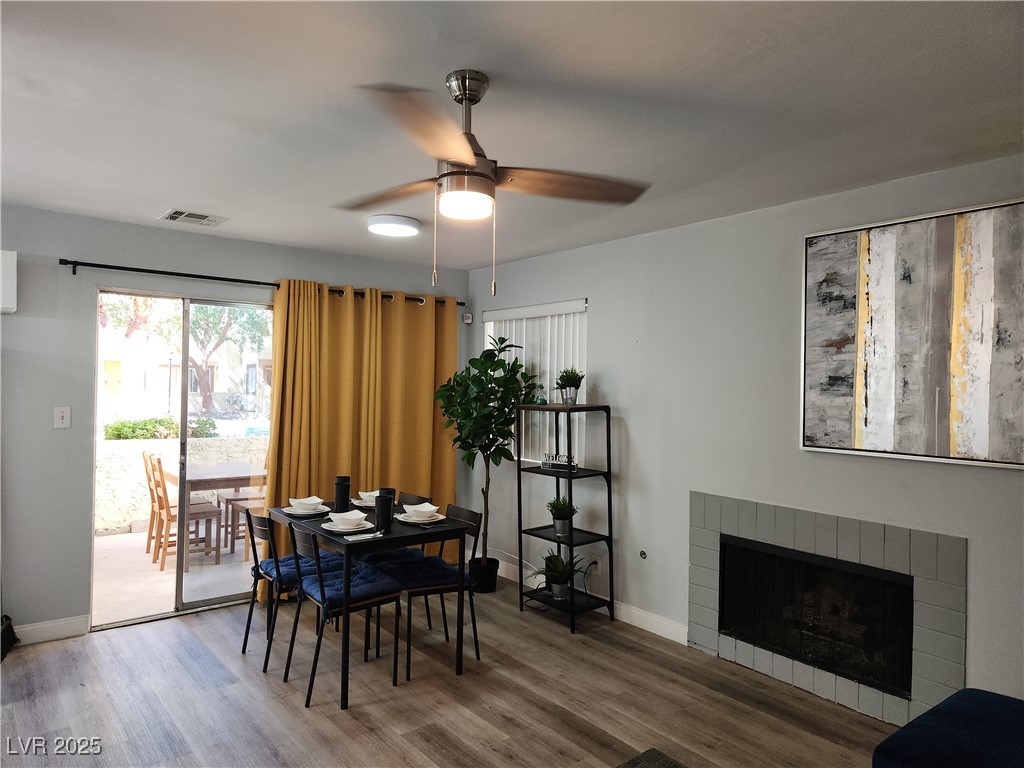 5045 Spencer Street, Unit B Las Vegas, NV 89119 - Photo 2 of 23 Dining area featuring ceiling fan, wood finished floors, and a fireplace