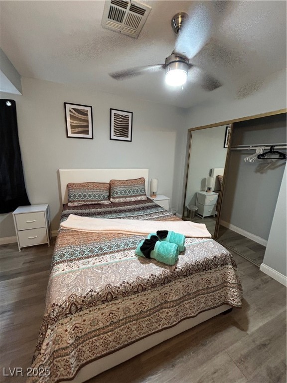 5045 Spencer Street, Unit B Las Vegas, NV 89119 - Photo 10 of 23 Bedroom featuring dark wood finished floors, a closet, a textured ceiling, and a ceiling fan