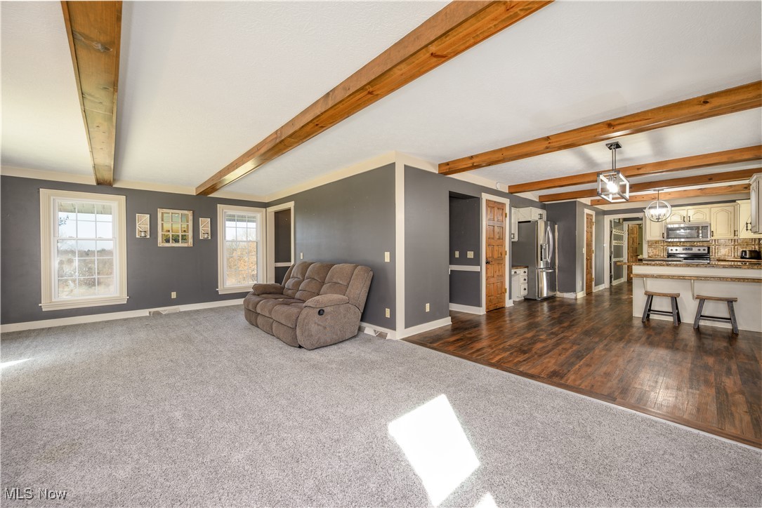 2061 Portage Line Road Mogadore, OH 44260 - Photo 18 of 48 Living area with dark wood finished floors, beam ceiling, baseboards, and dark carpet