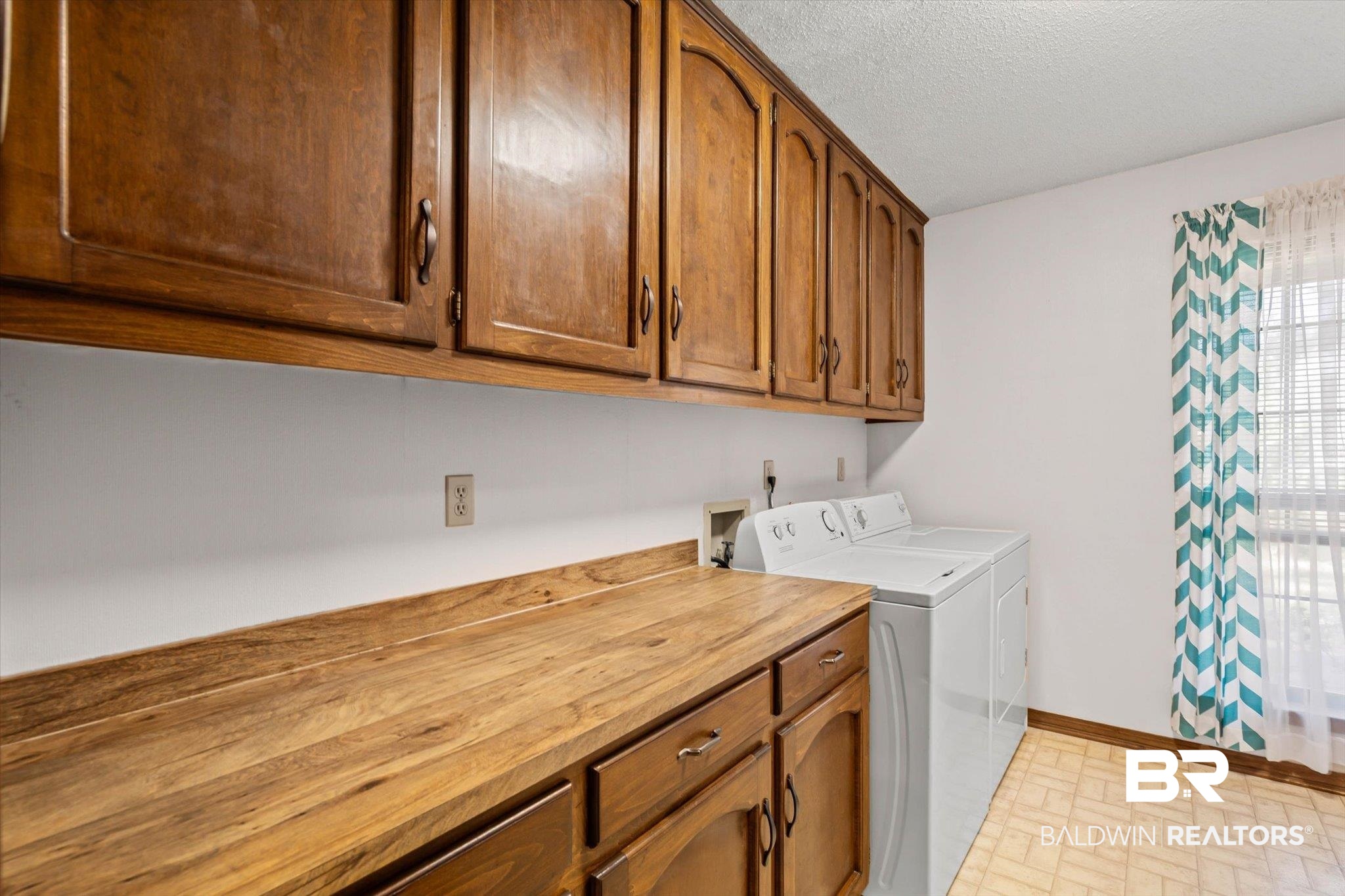 1900 Foxfire Road Mobile, AL 36618 - Photo 24 of 36 Washroom featuring cabinet space, washing machine and clothes dryer, and a textured ceiling