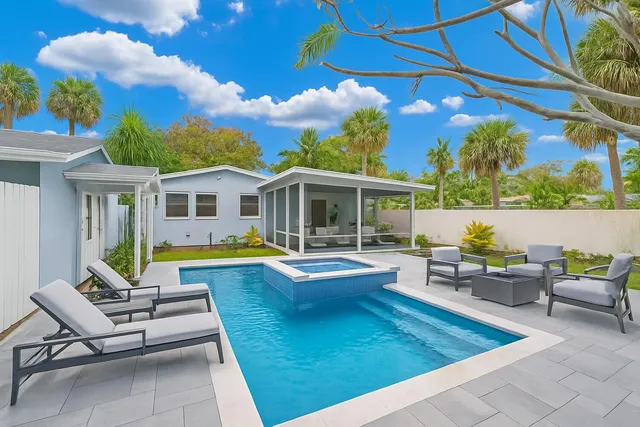 a view of a house with swimming pool and sitting area