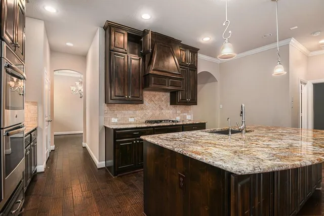 a kitchen with stainless steel appliances granite countertop a sink refrigerator and cabinets