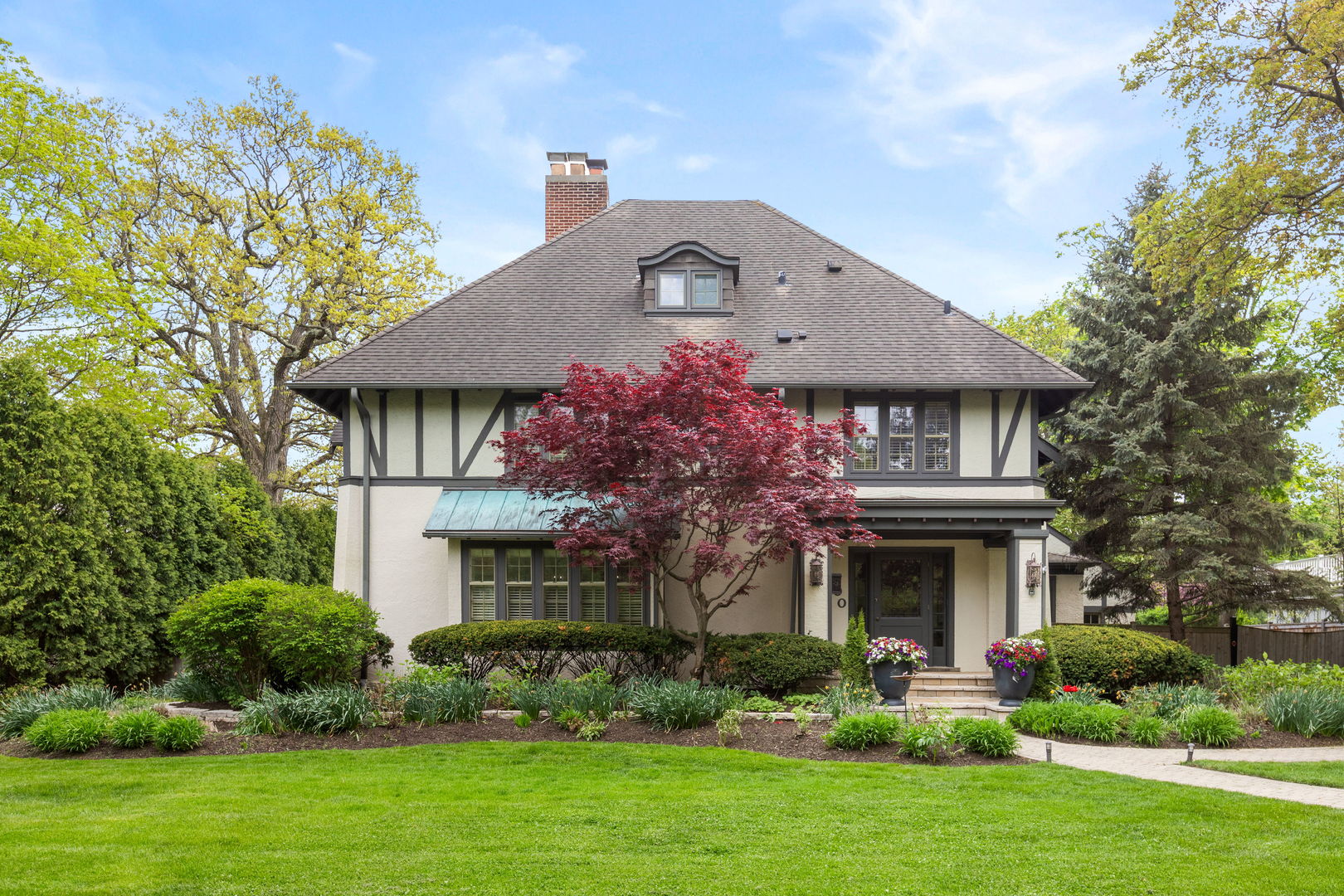 600 Ash Street Winnetka, IL 60093 - Photo 30 of 30 a front view of a house with a garden and plants