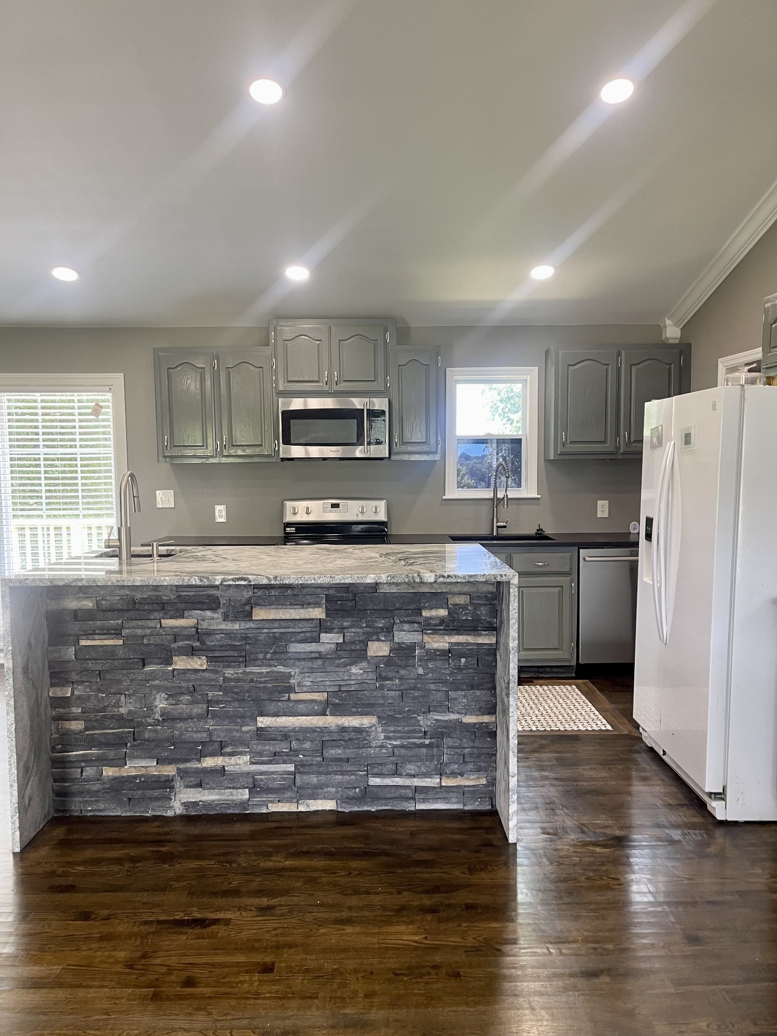 1213 West Point Road Lawrenceburg, TN 38464 - Photo 14 of 37 a kitchen with kitchen island granite countertop a stove a sink a refrigerator a center island and wooden floor