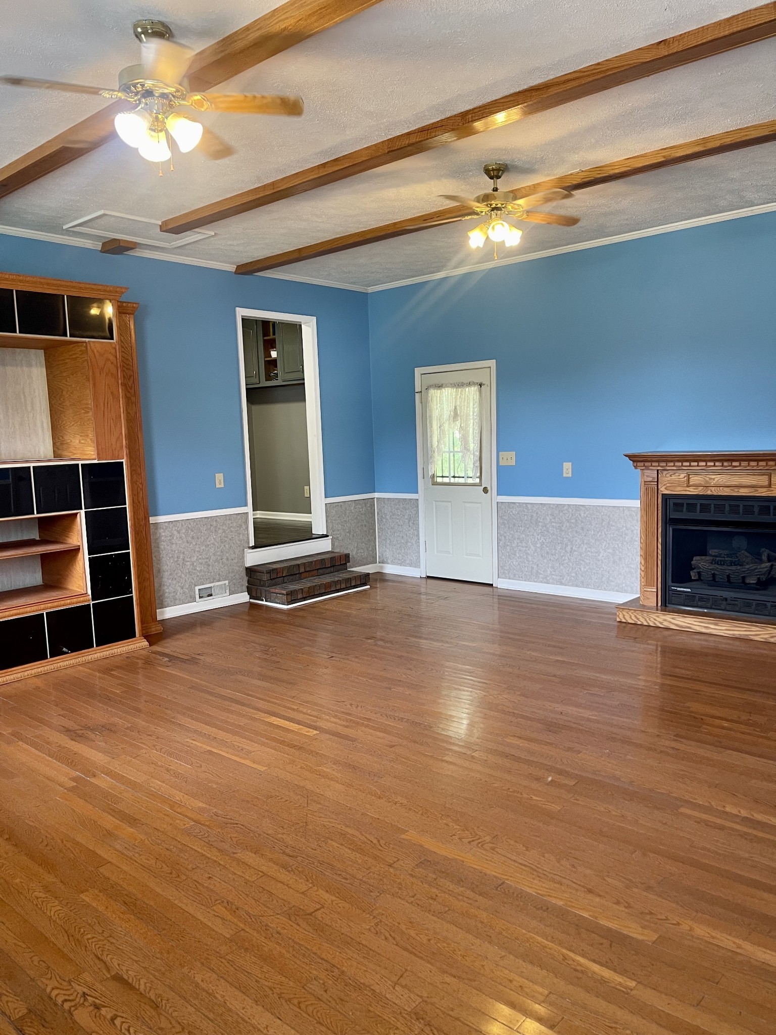 1213 West Point Road Lawrenceburg, TN 38464 - Photo 18 of 37 a view of a livingroom with wooden floor and a ceiling fan