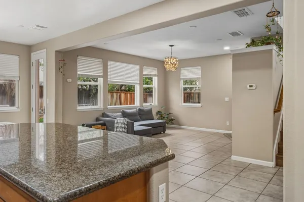 a view of a kitchen with granite countertop a sink and dishwasher with a dining table