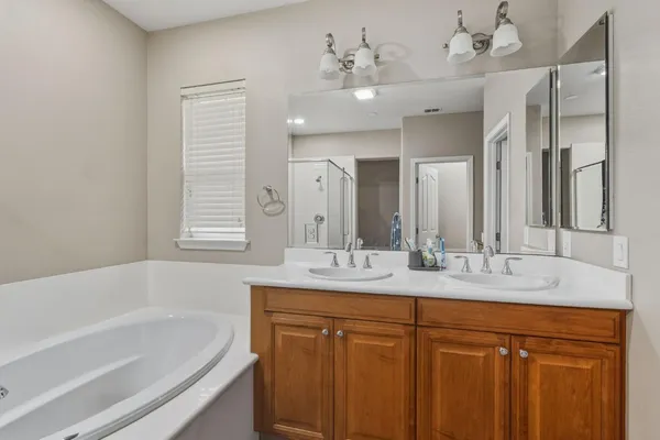 a bathroom with a granite countertop sink mirror bathtub and double