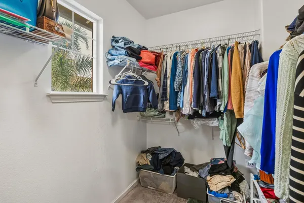 a view of walk in closet with clothes and shoes