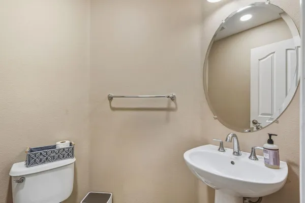 a bathroom with a sink a toilet and a mirror