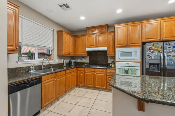 a kitchen with stainless steel appliances granite countertop a sink stove and refrigerator